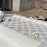 workers installing tiles in a custom pool Signature Pools
