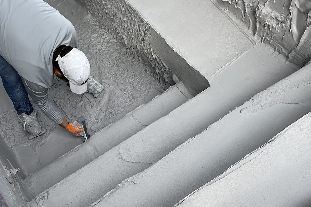 worker pouring concrete for a custom pool foundation by Signature Pools