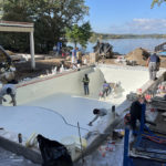 workers smoothing concrete for a custom pool foundation by Signature Pools