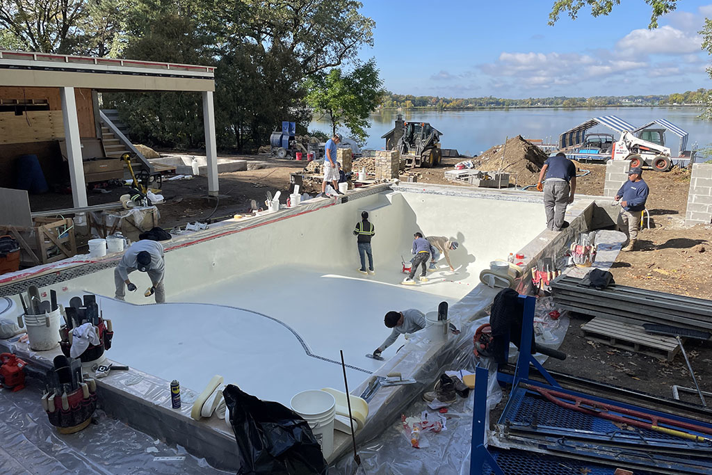 workers smoothing concrete for a custom pool foundation by Signature Pools