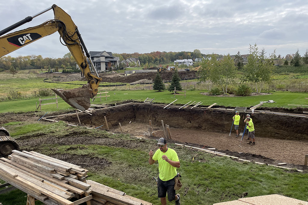 workers excavating a foundation for a custom pool design